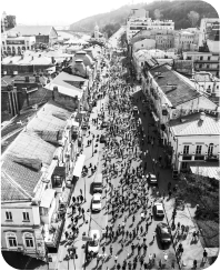 Hundreds of runners participate in the Nova Post marathon, running down a Kyiv street past buildings and cars.